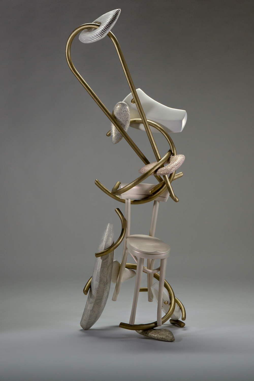 chair sculpture with curving gold lines and carved forms