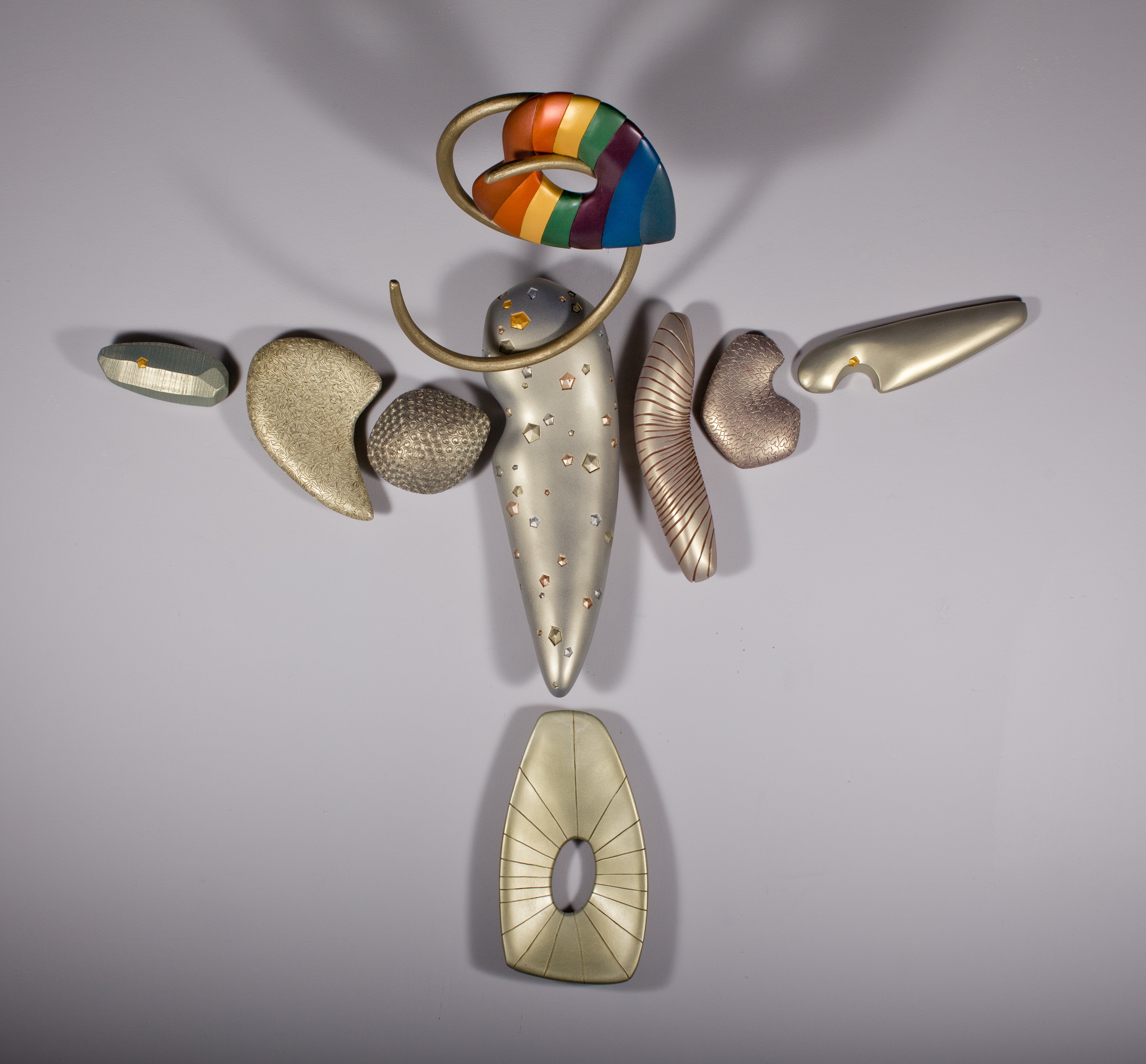 figurative arrangement of carved forms with rainbow heart head