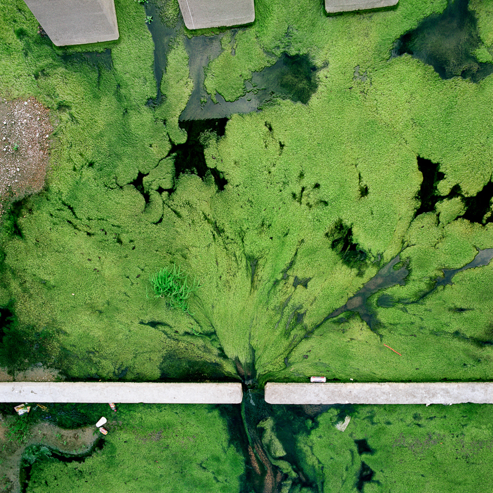 birds-eye view of green water flowing through space in wall