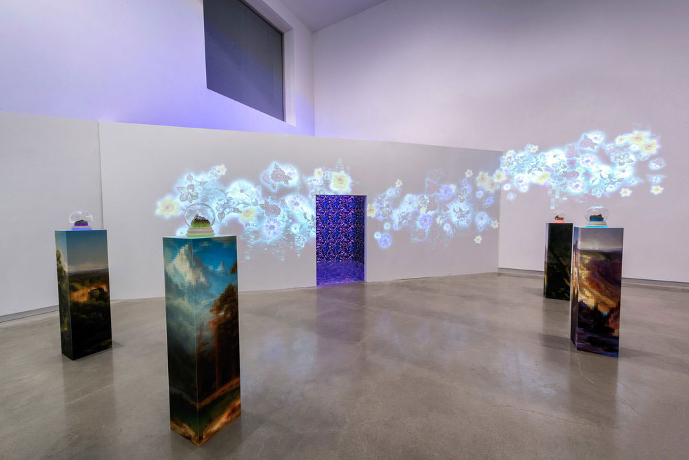 Gallery installation view of printed pedestals and projected forms on wall