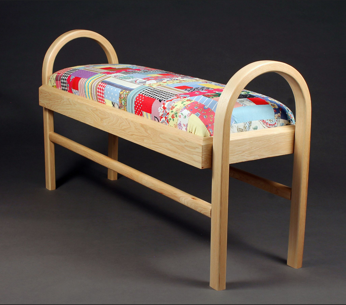 Wooden bench covered with family quilt