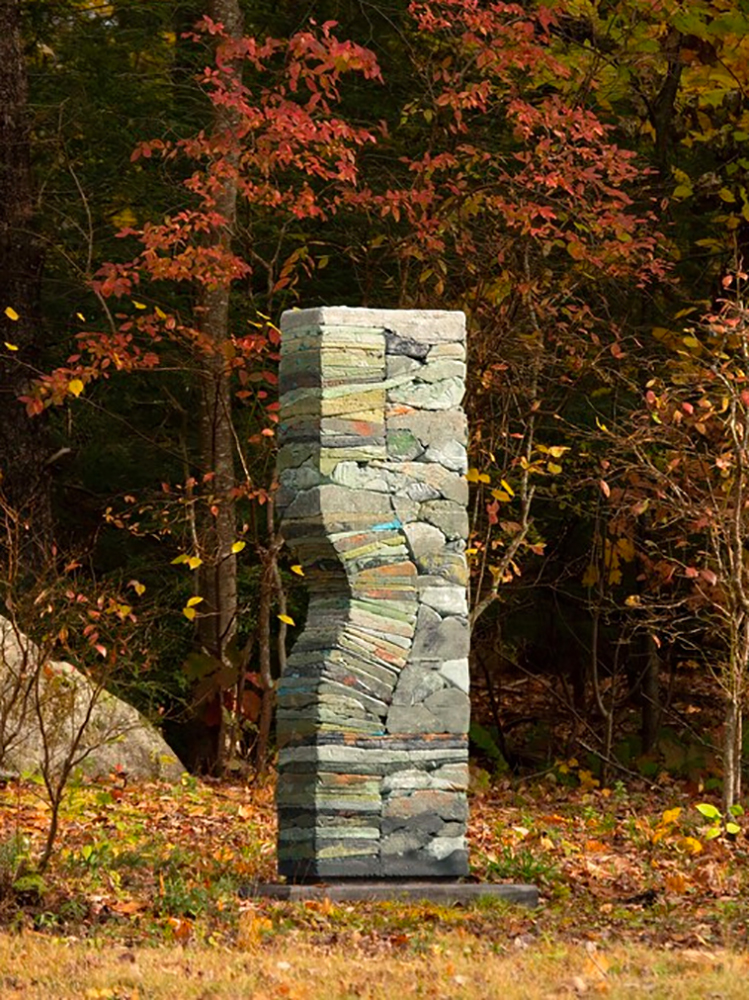 Stacked pigmented concrete sculpture in autumn background