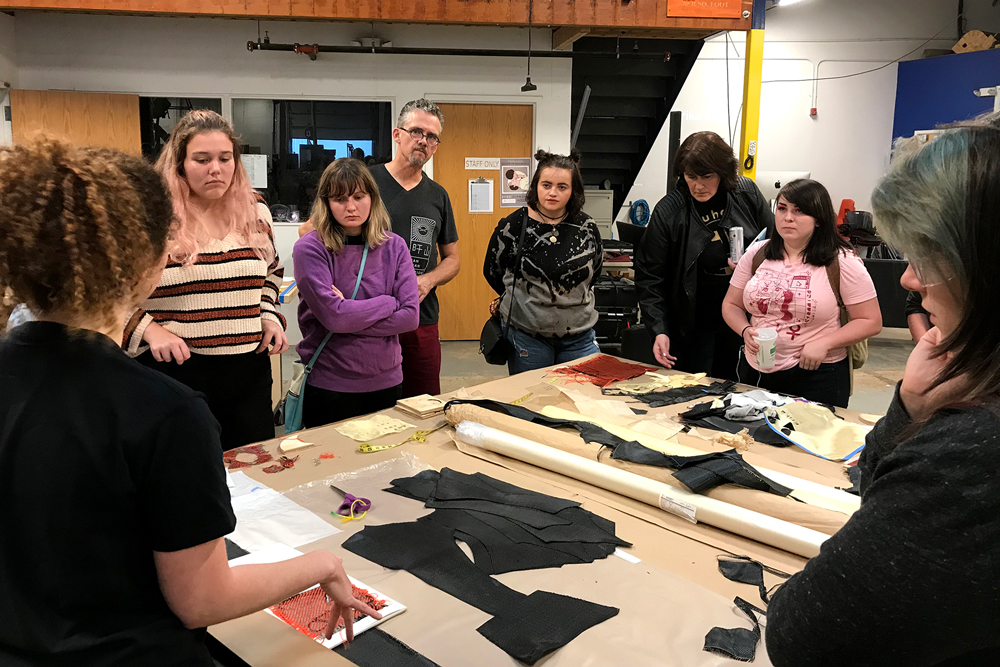 Close up view of Erika Diamond speaking to group of students about her materials and process